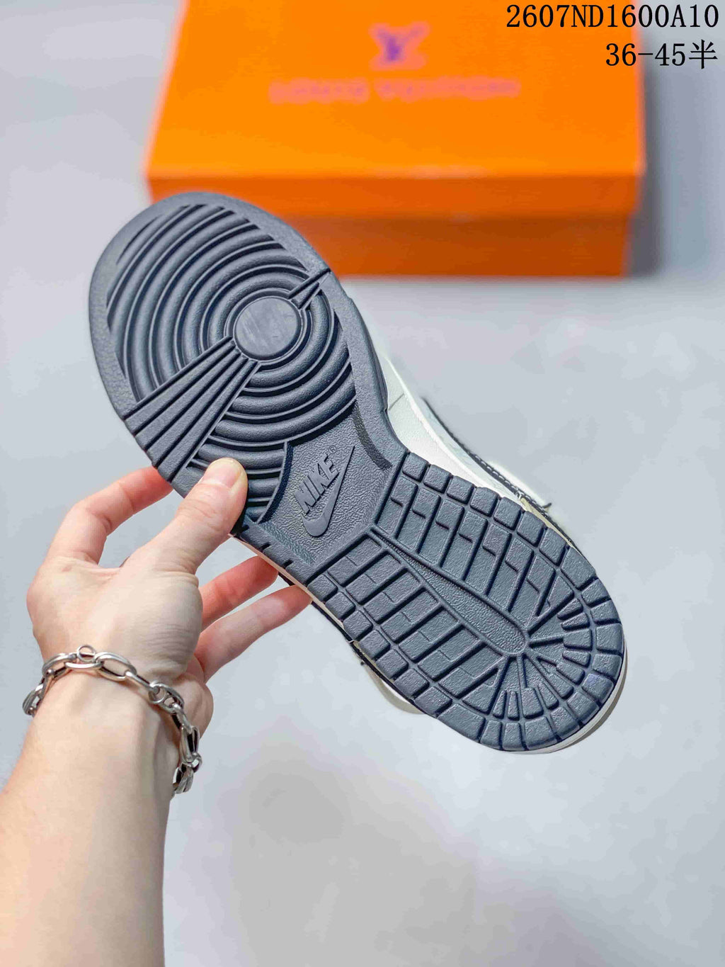 Close view of the sneaker outsole showing a dark rubber traction pattern with concentric circular grooves and segmented tread.