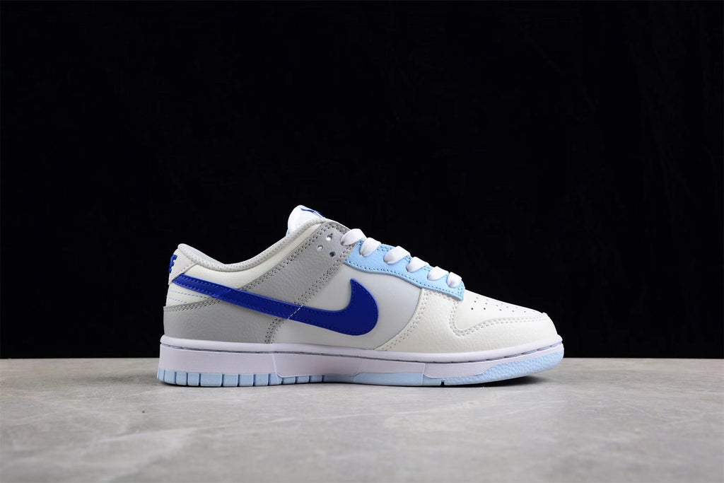 Full lateral view of the sneaker showing the white upper, gray overlays, and blue side branding.