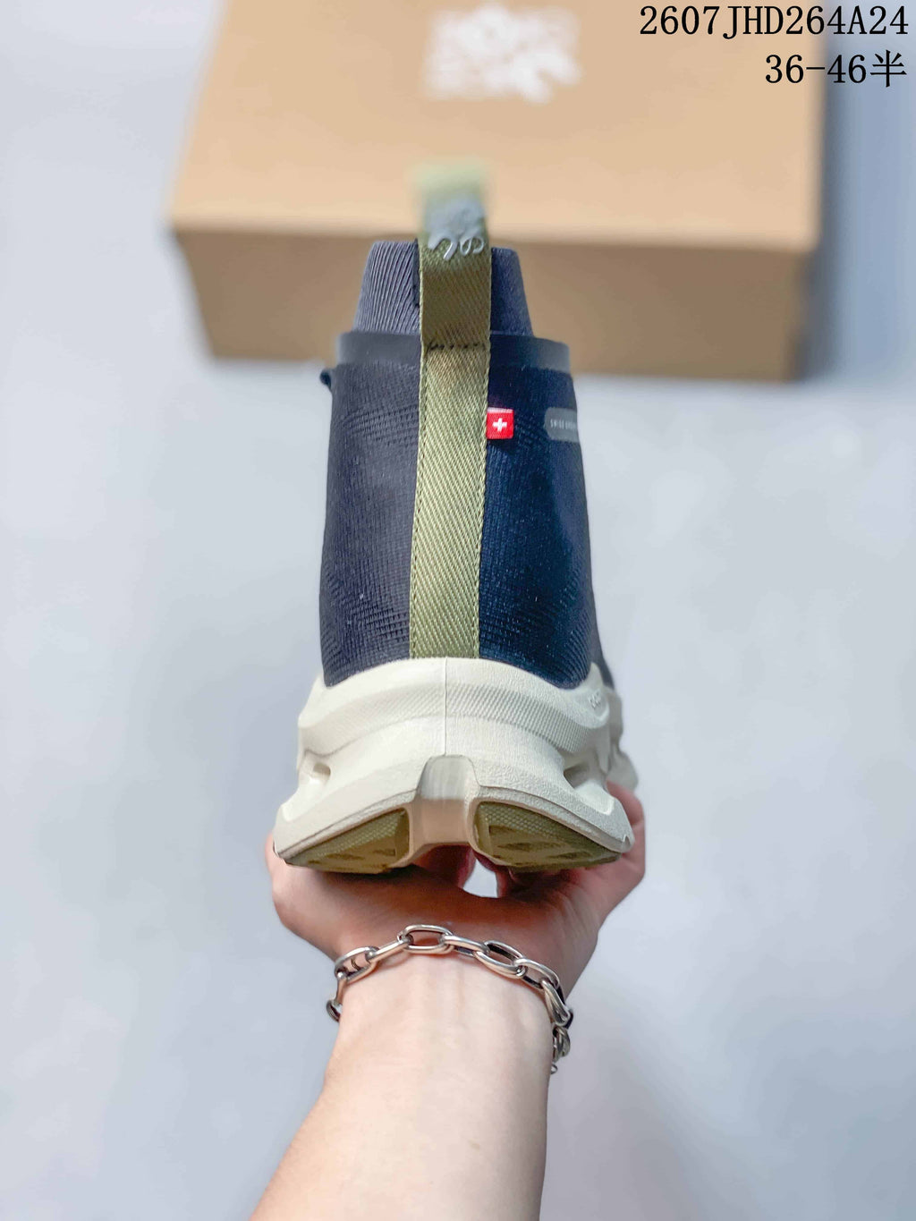 Rear view of the navy high-top sneaker showing the olive pull tab, heel branding details, and white sole.