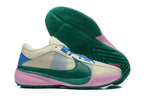 Cream basketball shoes with blue, green, and pink accents, shown with a green patterned outsole.