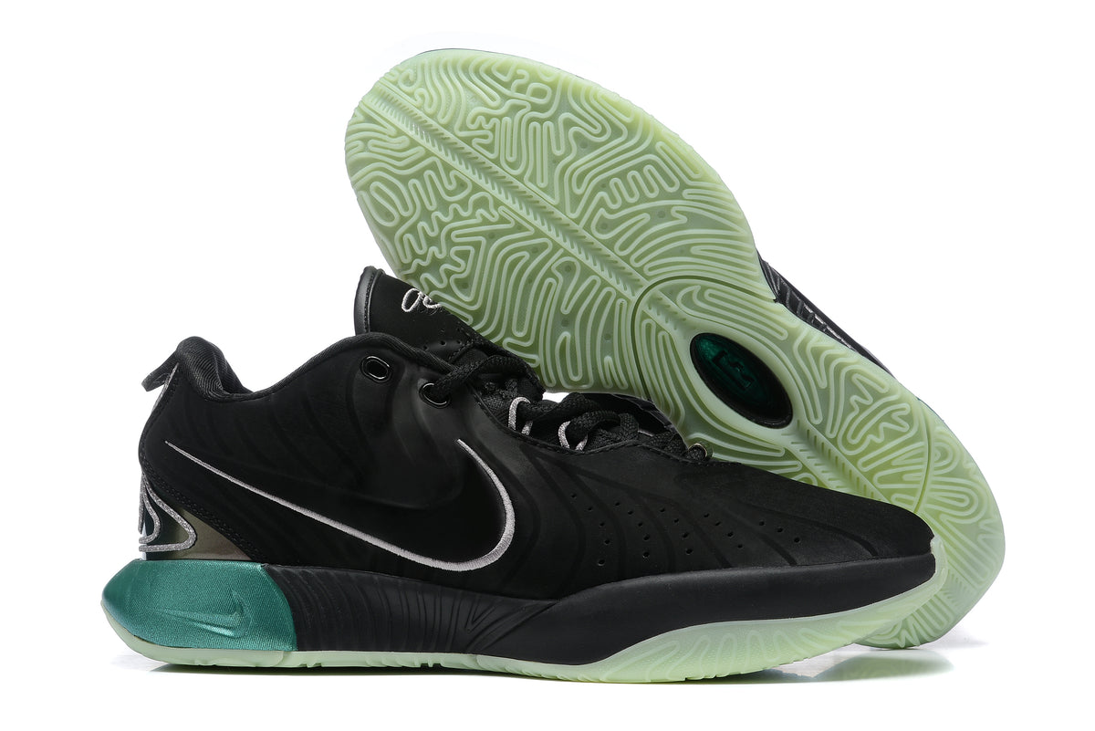 Black Nike basketball shoe with teal accents and a pale green outsole.