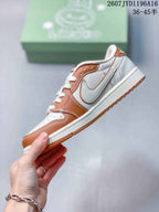 Side view highlighting the white swoosh-shaped overlay, brown panels, white midsole, and brown outsole.