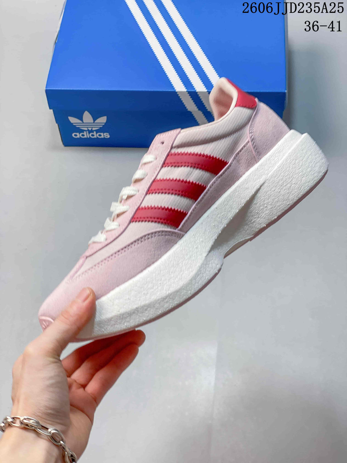 Side view of the sneaker showing the pink upper, three red stripes and white midsole.