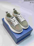 Pair of gray-green Dior lace-up sneakers with white laces and thick white soles