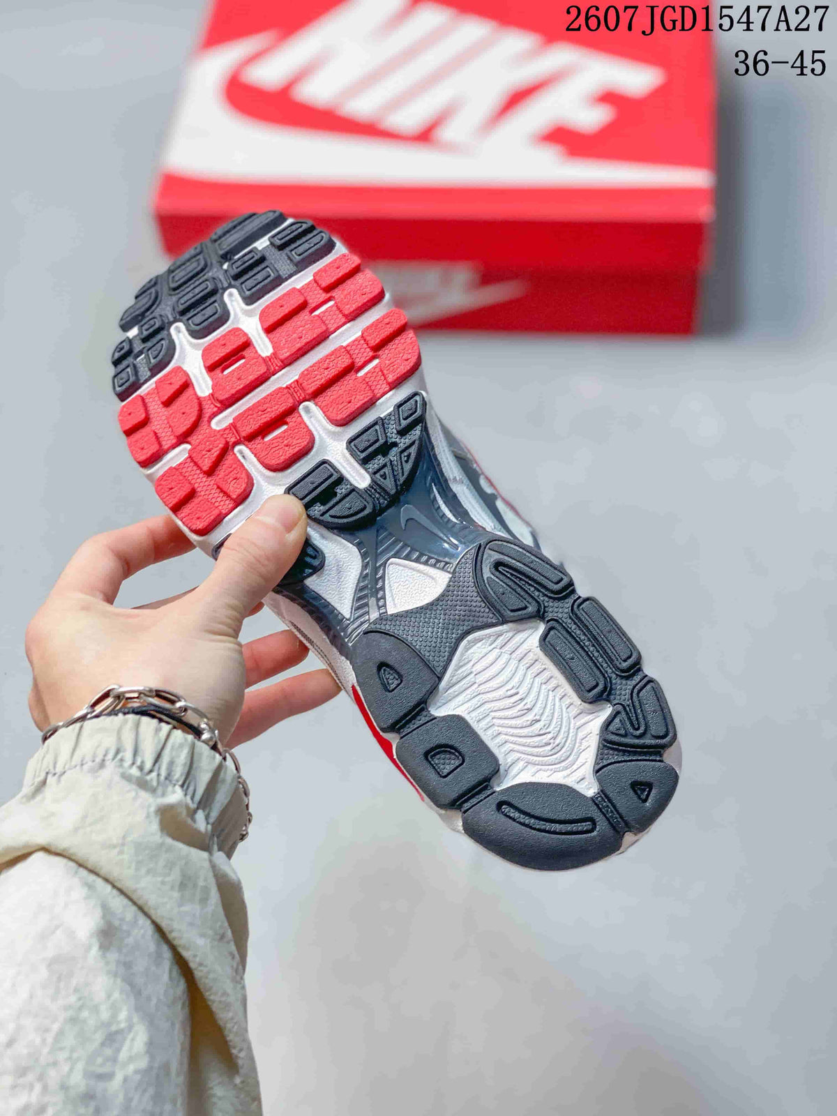 Nike Air Max Moto 2K outsole viewed from below, showing the segmented red, white, and dark tread pattern.