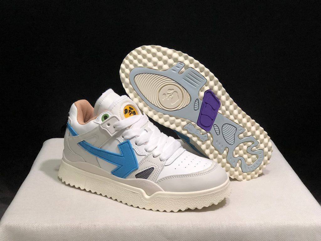 Angled view of one sneaker with the outsole exposed, showing its textured cream-colored base and colored traction sections.