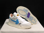 Angled view of one sneaker with the outsole exposed, showing its textured cream-colored base and colored traction sections.