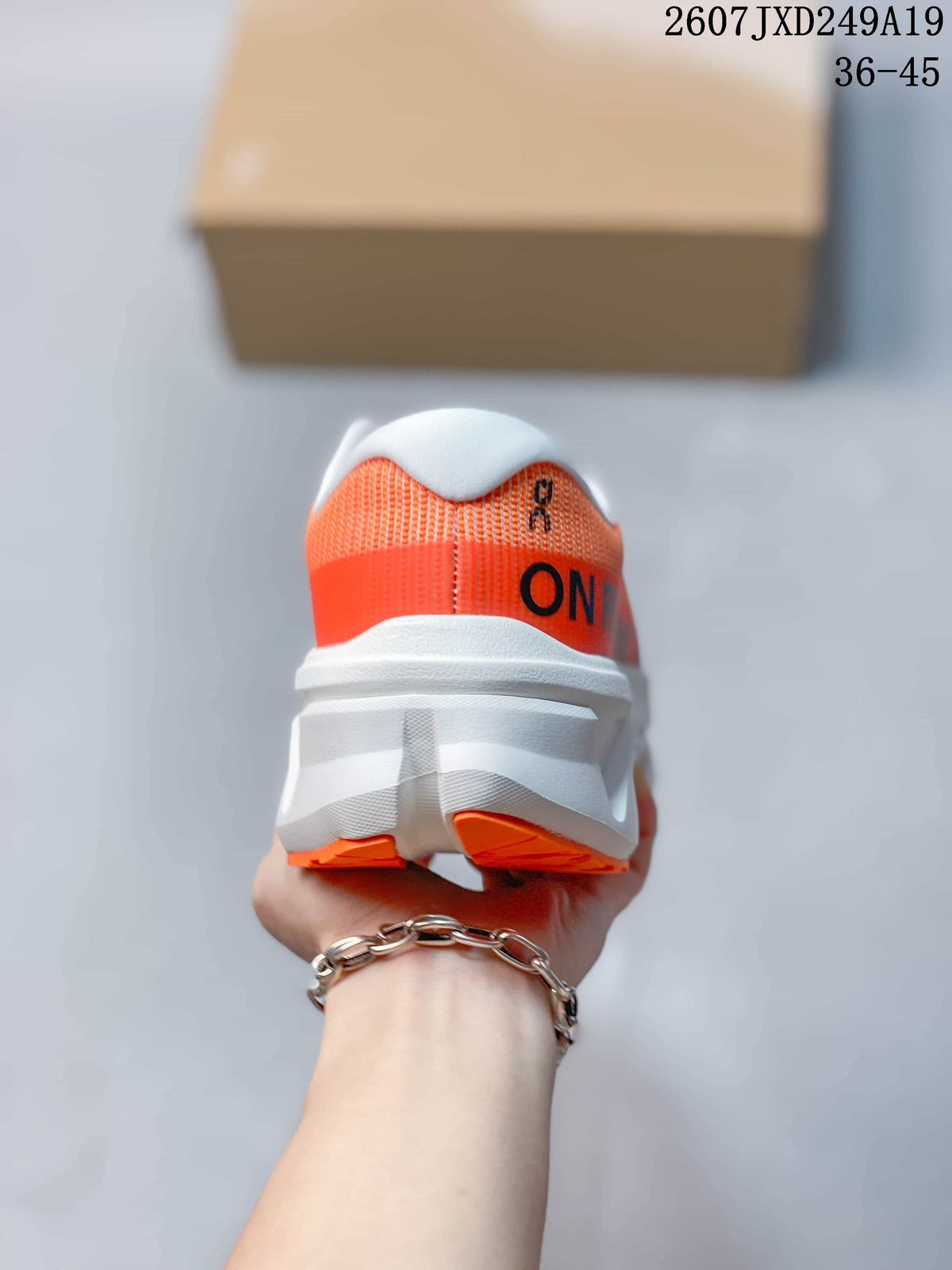 Rear view of an orange sneaker showing the white heel collar, white midsole, and orange outsole sections.