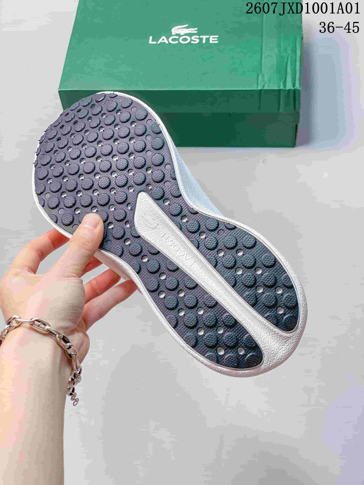 Close-up of the sneaker outsole with circular tread and a green Lacoste box behind it