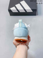 Rear view of a pale blue and white adidas JOG 2.0 sneaker