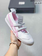 White Mary Jane sneaker with pink side stripes, pink interior lining and two adjustable straps.