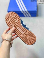 Close view of the gum-colored outsole with circular tread details and adidas branding.