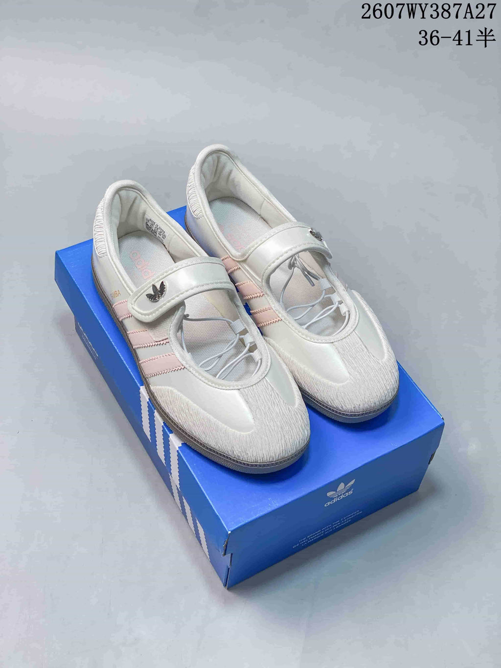 Pair of white and pink adidas Samba Jane-style sneakers with Mary Jane straps displayed on a blue shoebox; image text shows product code 2607WY387A27 and size range 36–41.5.