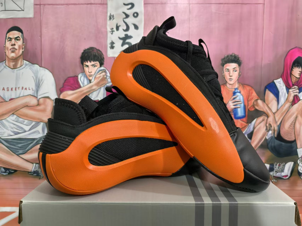 Pair of black and orange sneakers shown from the side