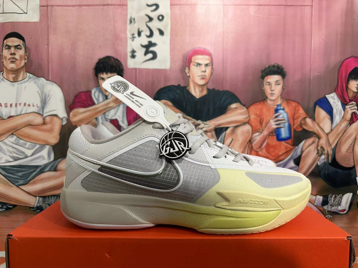 Side profile of a gray and pale yellow Nike basketball shoe with Swoosh detailing.