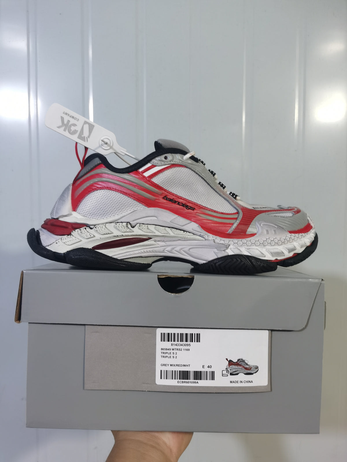 ASICS 1169 grey, red and white sneaker shown on its box, with the box label visible.