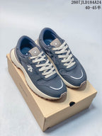 Pair of navy DESCENTE Chron low-top sneakers with cream laces displayed on a DESCENTE shoe box.
