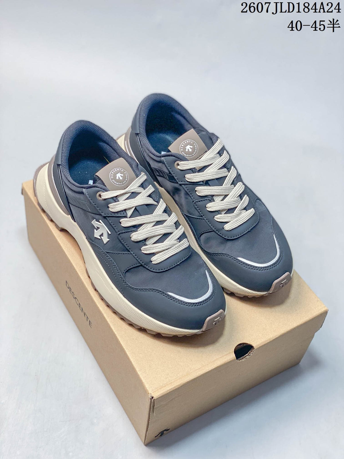 Pair of navy DESCENTE Chron low-top sneakers with cream laces displayed on a DESCENTE shoe box.