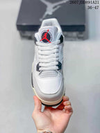 Front view showing the white laces, mesh tongue panel, and circular red and black tongue logo.