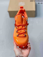 Top view of an orange sneaker showing the rounded toe, layered lace system, metallic-style lace hardware, and LOEWE branding.