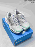 Pair of light gray and mint HOKA low-top running shoes displayed on a blue shoe box.