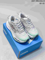 Pair of light gray and mint HOKA low-top running shoes displayed on a blue shoe box.