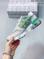 Side profile of the gray and green sneaker showing layered panels, contrast detailing, and the patterned outsole.