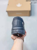 Rear view of the black sneaker showing the heel construction, layered sole, and outsole edge.