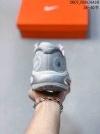 Rear view of a light gray Nike Journey Run shoe showing the padded collar, heel structure and textured outsole.