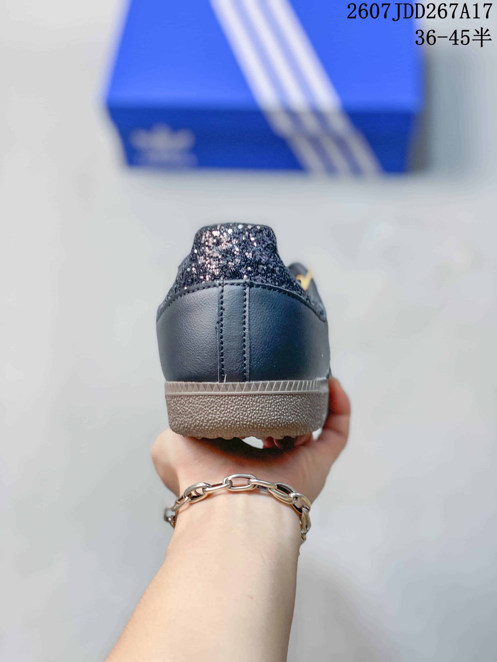 Rear view of the black sneaker showing the stitched heel panel and glitter-style heel tab.