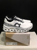 Side view of On Cloudmonster 2 shoes on their box