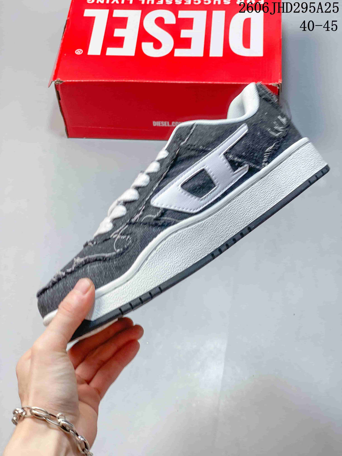 Side view of the charcoal low-top sneaker with a white side logo and white midsole