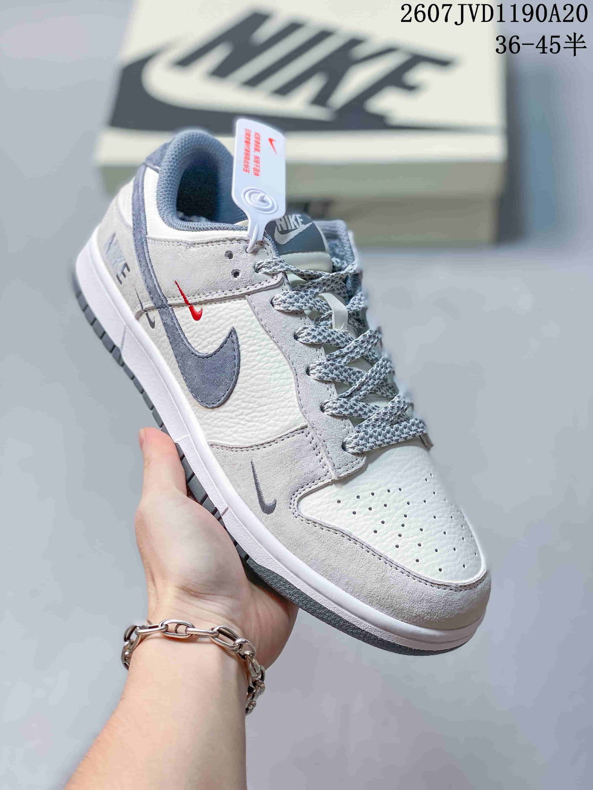 Close side view of an off-white Nike SB Dunk Low sneaker showing layered panels, contrasting Swoosh branding and patterned laces.