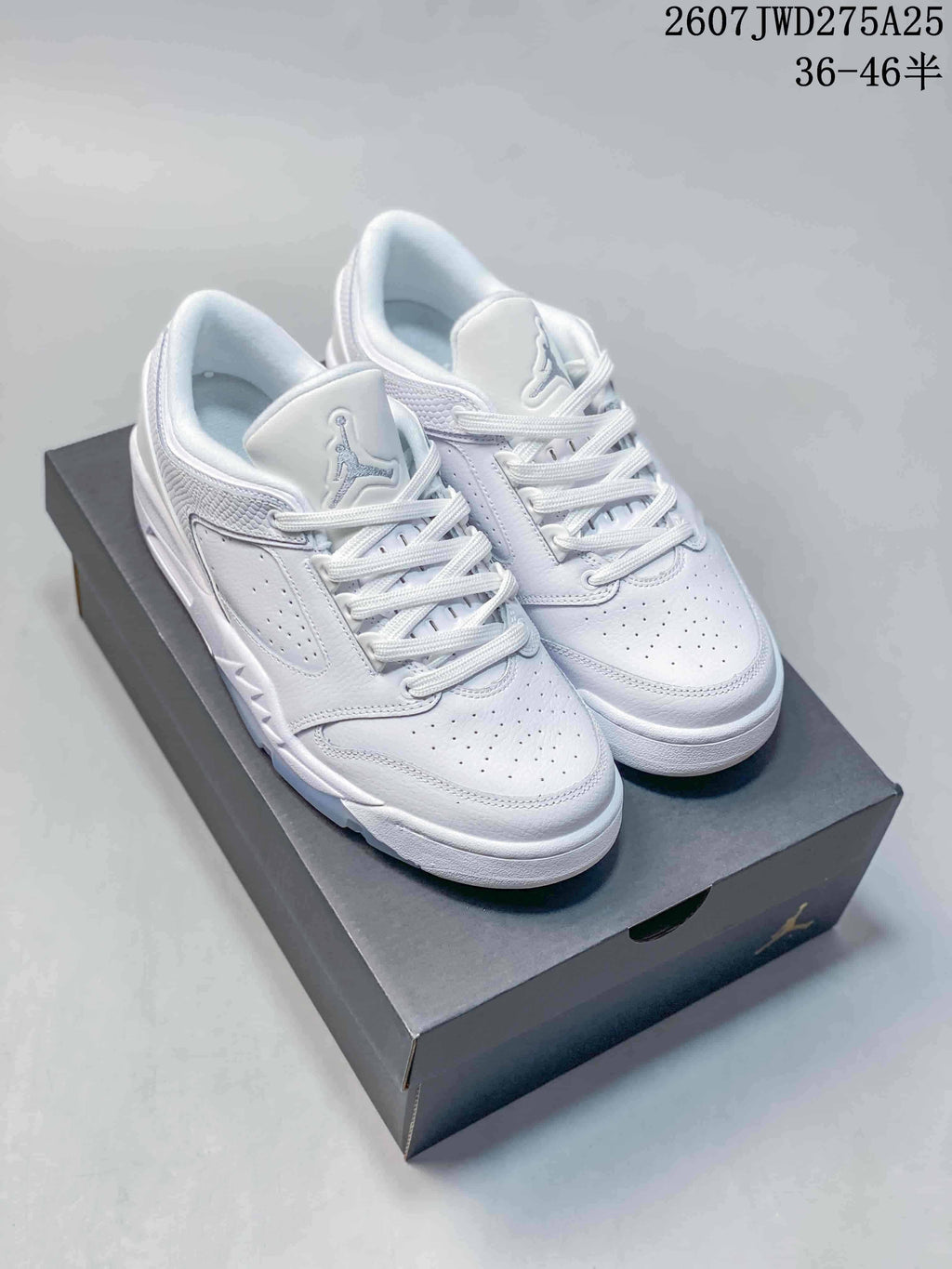 Pair of white Nike Air Jordan Sixty Plus Low sneakers displayed on a black shoebox.