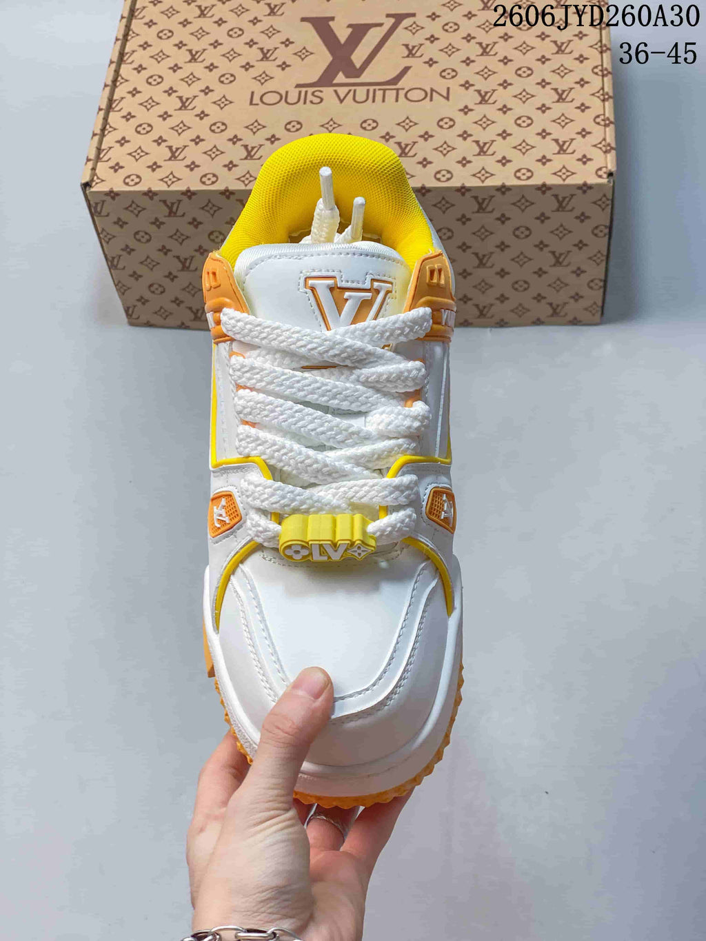 Top view of a white Trainer Maxi sneaker with thick laces and yellow lining.