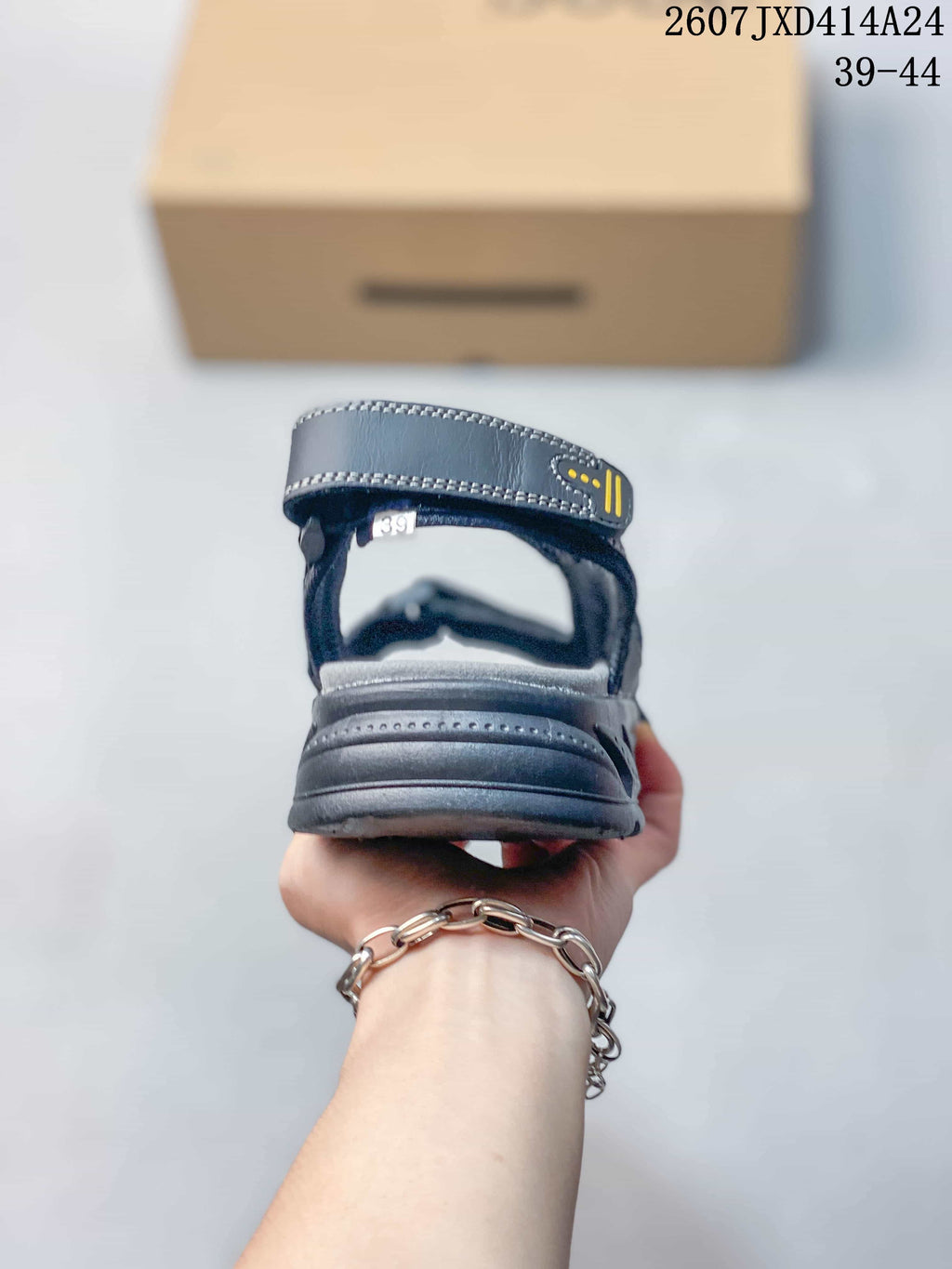 Rear view of a dark black sandal showing the heel strap, contrasting stitching and a visible size marking of 39.