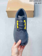 Top-down view of the shoe showing its laces, yellow lace supports, and dark grey upper.