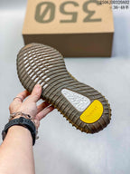 Close-up of the tan ribbed outsole with textured traction sections and yellow and white outsole inserts.