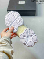Underside view of the sneaker showing the segmented white outsole and cream-toned midsole section.