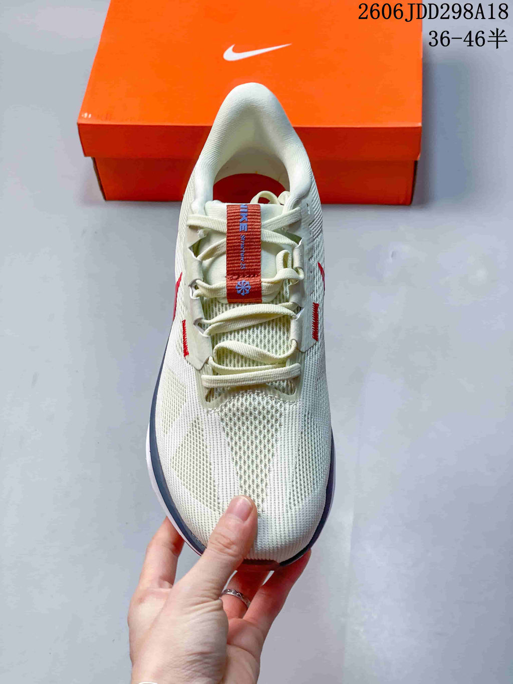 Top view of the white mesh sneaker showing the laces, tongue, and red-blue tongue detail.