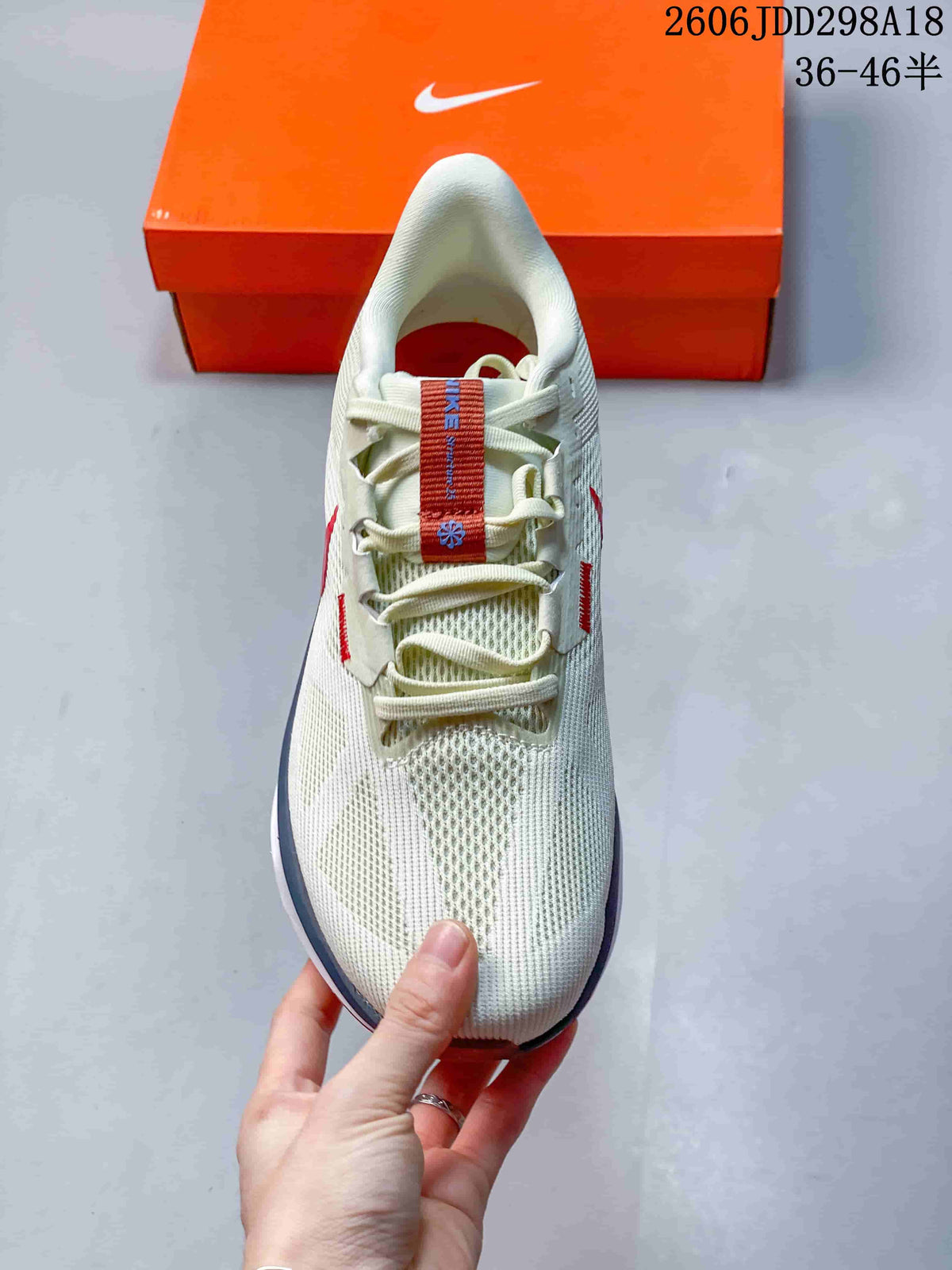 Top view of the white mesh sneaker showing the laces, tongue, and red-blue tongue detail.