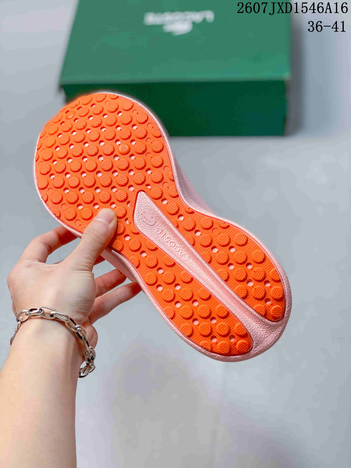 Close view of the orange patterned outsole and pink midsole of a Lacoste sneaker.