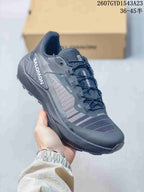 All-black Salomon Genesis shoe showing the mesh-style upper, overlays and lugged outsole.