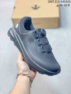 Angled side view of the black Descente sneaker showing the upper, heel collar, side branding and outsole.