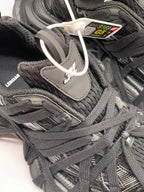 Close-up of the black upper, layered laces, textured panels, and tongue branding.