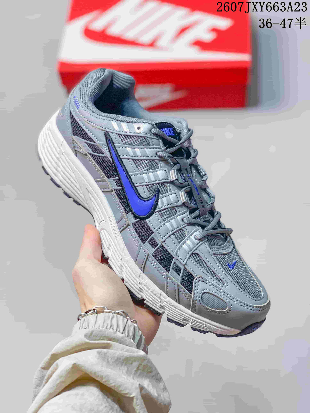Angled side view of the gray and blue Nike P-6000 sneaker with contrasting blue branding.