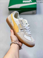 Angled side view showing the yellow PUMA side stripe, lace-up construction, and gum outsole.