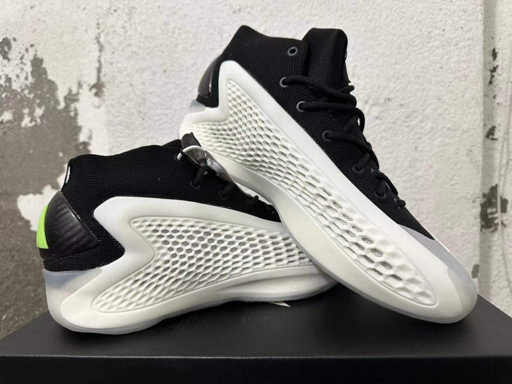 Pair of black-and-white sneakers displayed from the side, with lime heel accents