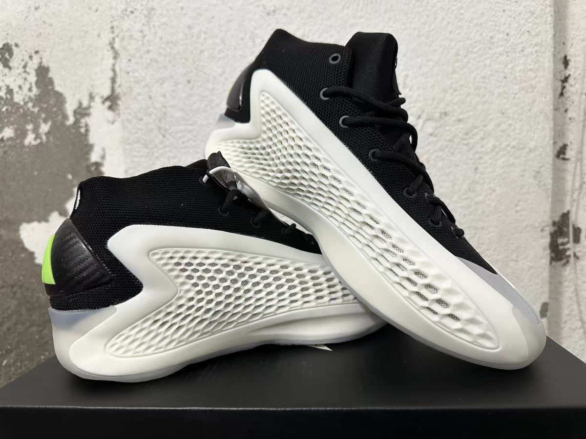 Pair of black-and-white sneakers displayed from the side, with lime heel accents
