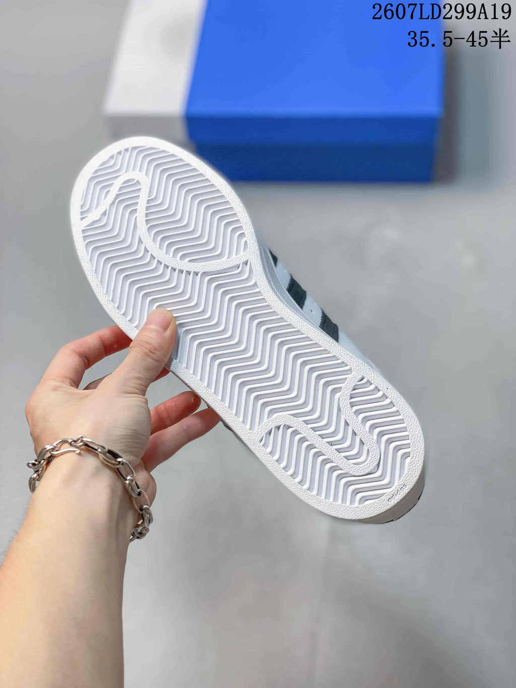 Close-up of the white textured outsole of an adidas Superstar sneaker with a zigzag tread pattern.